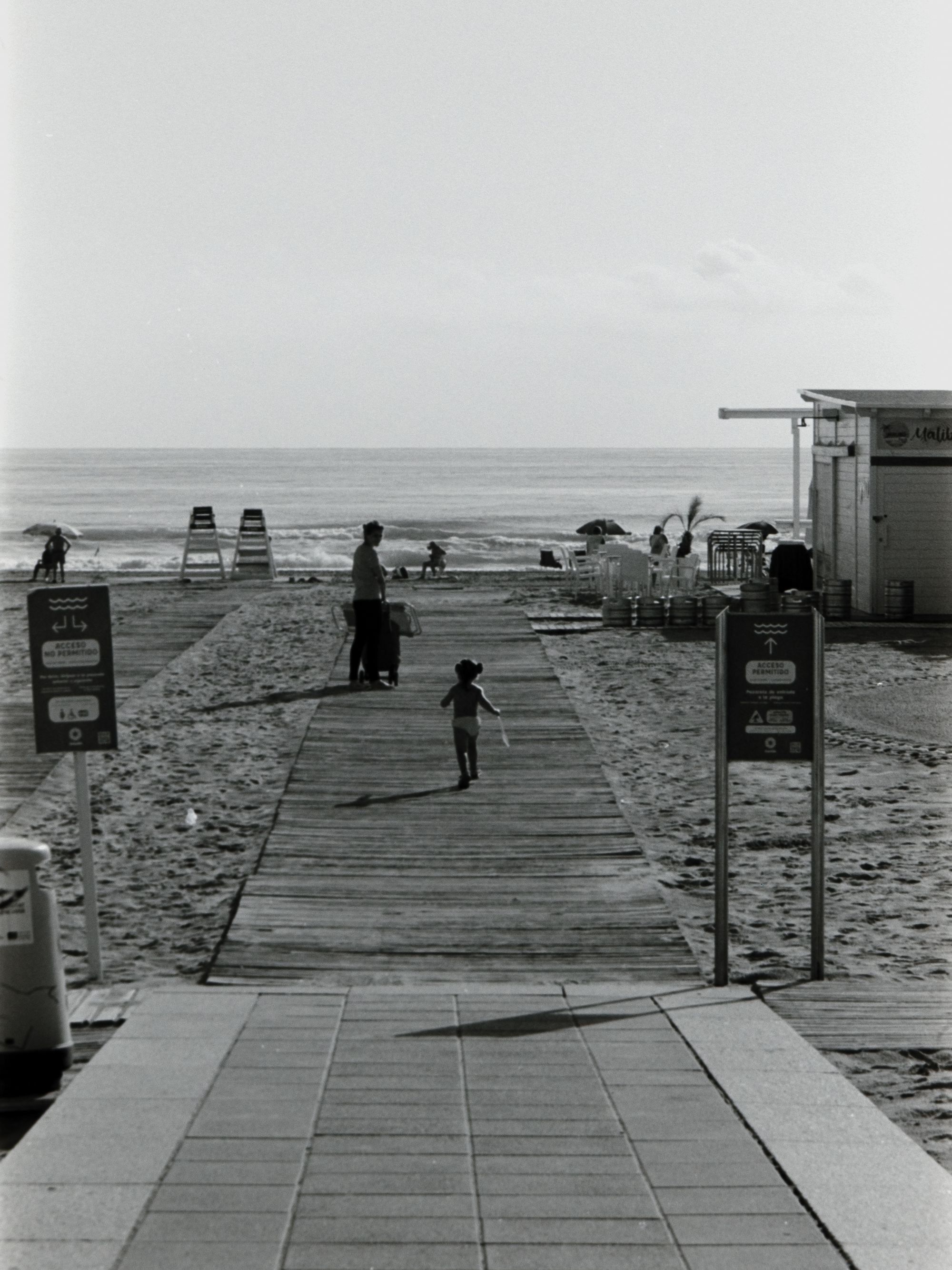 A kid follows her mom into the beach